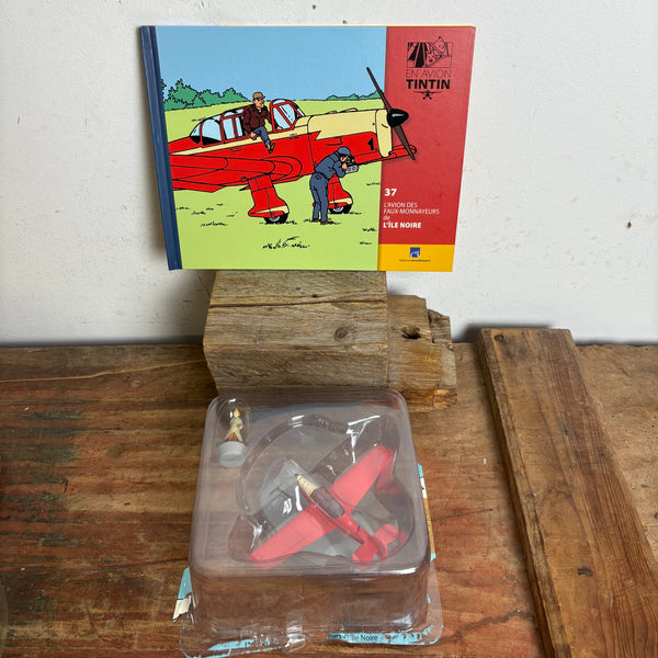 Modell Figur und Buch Tim und Struppi Das rote bordurische Jagdflugzeug mit Tim aus Die Schwarze Insel
